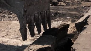 Kazı makinesinin kovası beton kaldırımları yıkıyor