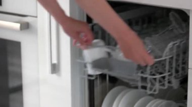 Kadın elleri bulaşık makinesini evde boşaltıyor.