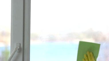 Pencere silici kadın camları temizliyor.