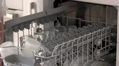 Eller bulaşık makinesinden temiz cam parçalarını alır.