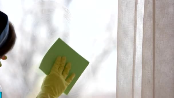 Жіноча рука миє вікно жінка прибирає скло з миючим засобом — стокове відео
