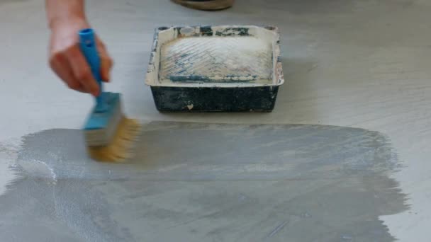 Hus målare primer betong golv arbetare förbereda golvet under målning — Stockvideo