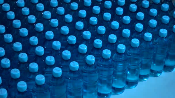 Много бутылок с водой с голубыми колпачками — стоковое видео