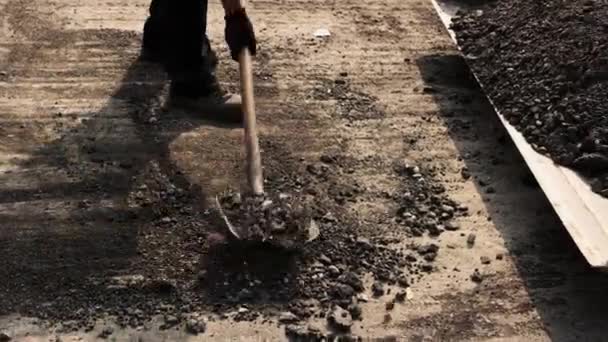 Работник с лопатой, принимающий асфальт — стоковое видео