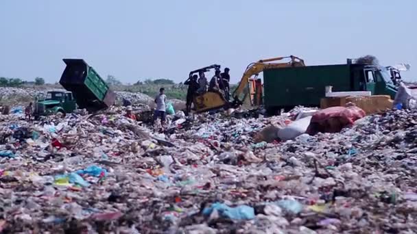 Працівники міських сміттєвозів розвантажують сміття на смітник — стокове відео