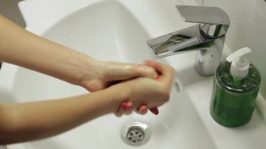 Kız ellerini sabun el hijyeniyle yıkıyor.