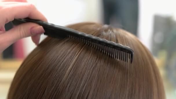 Mano con peine cepillado pelo pelo femenino de cerca — Vídeos de Stock