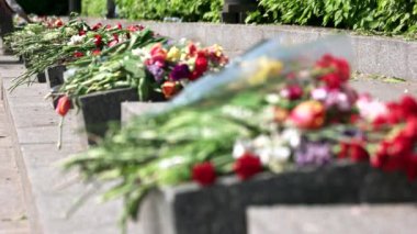 Anıt granit taşların üzerindeki buketler kapanıyor.