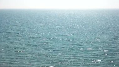 Güneş altında parlayan deniz mavi su ve ufukta