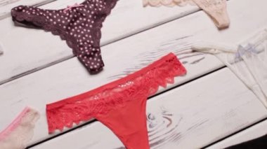 Beyaz ahşap zeminde parlak ve siyah külotlar.