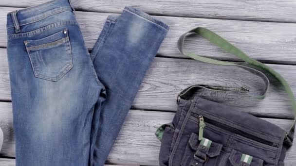 Blauwe jeans en witte schoenen klassieke rubberen schoenen en tas nieuwe aanwinsten in jeans winkel — Stockvideo