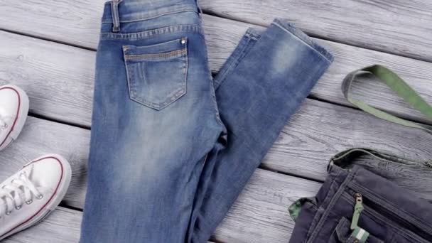 Сині джинси і джинсові гаманець біле полотно взуття і джинси — стокове відео