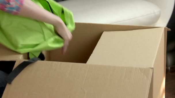 Женские руки упаковка коробки картонная коробка с одеждой — стоковое видео