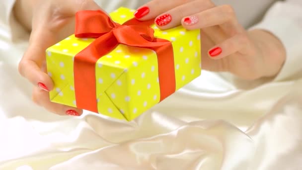 Güzel ellerde hediye kutusu ağır çekimde genç kadın elleri romantik tırnak tasarımı ile — Stok video