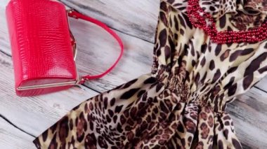 Leopar elbisesi ve parlak bilezikler sandaletleri lüks elbiseyle donatır.