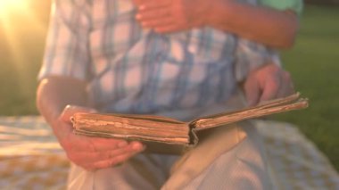 Erkek eli, sayfaları çeviren bir kitap adamı tutuyor.