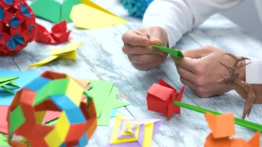 origami erkek elleriyle yeşil kağıttan origami yapıyor.