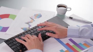 Kablosuz klavyede yazan ve kahve içen bir iş kadını.