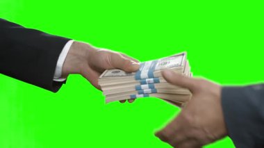 Erkek eli dolar destesini uzatır fileto arka planında anahtar devir teslim eder