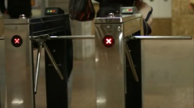 İnsanlar turnikelerden geçiyorlar Turnikeleri kontrol ediyorlar
