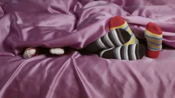 Dzieci nogi w kolorowe skarpetki dzieci na łóżku — Wideo stockowe