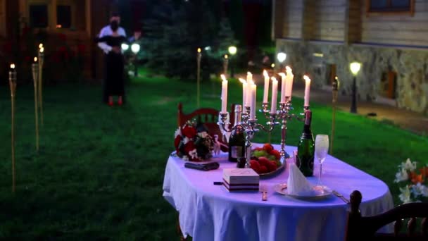 Para tańczy na podwórku romantyczna kolacja przy świecach — Wideo stockowe