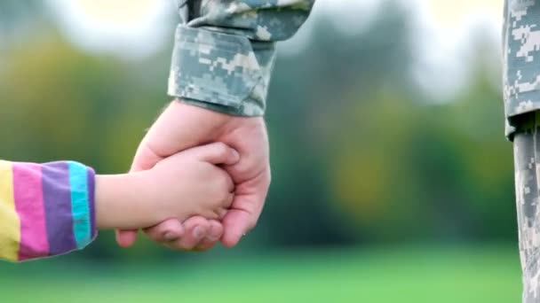 Las manos del padre y el niño tomados de la mano del soldado militar — Vídeo de stock