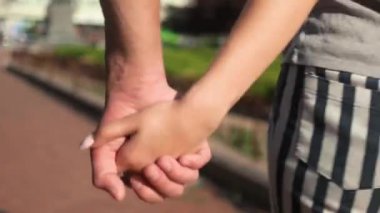 Genç çift el ele tutuşup yakınlaşıyor.