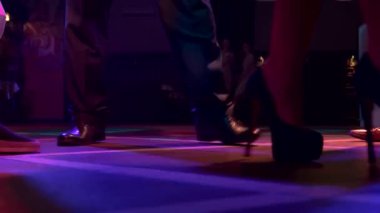 Yüksek topuklularla dans eden insanların bacakları ve tarz dansı.