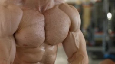 Kaslı gövde ve kollarını geliştiren iri kaslı bir vücut.