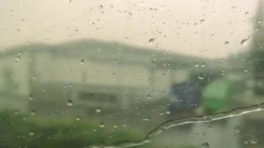 Tren penceresi ve su damlaları bulanık doğa ve binalar