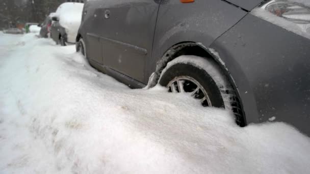 Крупным планом колес, застрявших в снежном дрейфе автомобиля, покрытого снегом — стоковое видео