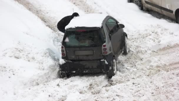 Fahrer gräbt Auto bei Schneeglätte aus — Stockvideo
