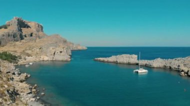 Tekne, doğal kaya oluşumuyla bir deniz koyuna yanaştı.