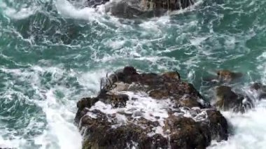 Dalgalar kayalara çarpıyor.