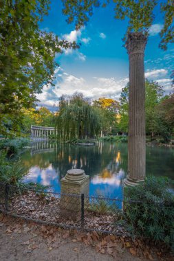 Paris, Fransa - 10 11 2020: Sonbaharda Parc Monceau 'da altın saat. Korint sütunlarıyla çevrili Oval havza