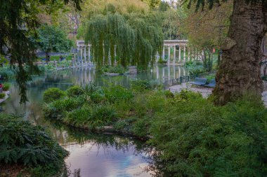 Paris, Fransa - 10 11 2020: Sonbaharda Parc Monceau 'da altın saat. Korint sütunlarıyla çevrili Oval havza