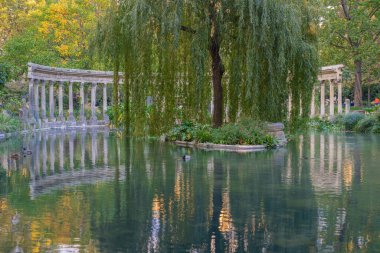 Paris, Fransa - 10 11 2020: Sonbaharda Parc Monceau 'da altın saat. Korint sütunlarıyla çevrili Oval havza