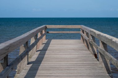 Denizin önündeki ahşap rıhtımın görüntüsü Balıkçı İskelesi ve mavi gökyüzü arka planı