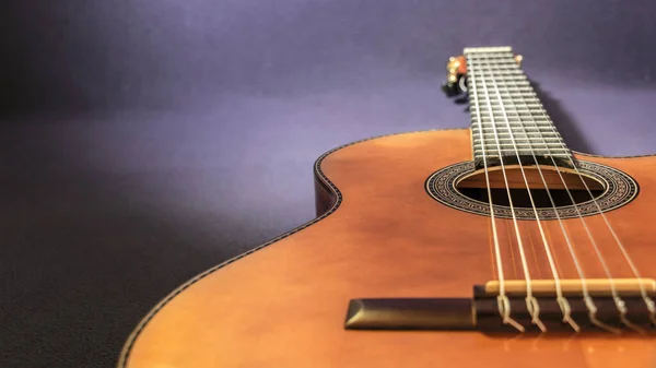 Zbliżenie Gitary Akustycznej Leżącej Ciemnym Tle Oświetlającej Tylko Gitarę — Zdjęcie stockowe