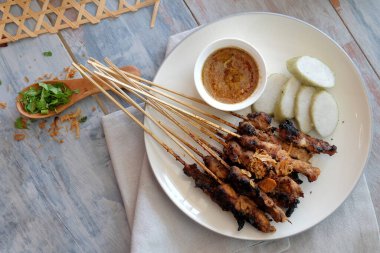 Pirinç keki ve fıstık soslu keçi eti, Yogyakarta, Endonezya 'dan geleneksel yemekler ahşap masada..