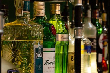 SINNAI, SARDINIA, İtalya - 07 Ağustos 2020: İtalya 'daki bir barın rafında çeşitli renkli alkol şişeleri sergilendi