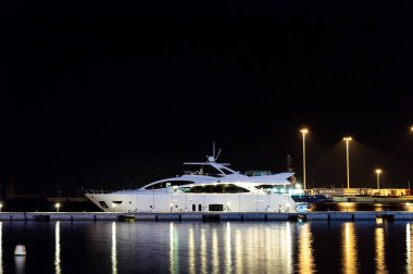 CAGLIARI, SARDINIA, İTALYA - 14 HAZİRAN 2020: Akdeniz 'e demirlemiş, geceleri iskeledeki modern özel yat