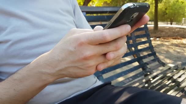 Joven Caucásico Sentado Banco Leyendo Teléfono Mensaje Texto Teléfono Móvil — Vídeo de stock