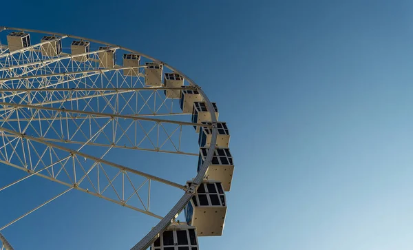 Carnival Ferris Wheel with Clean Skies with Empty Space low angle view close up with blue sky and clouds in background, copy space