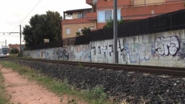 Şehir ulaşımı, seyahat, altyapı, metropol konsepti - Hareket halindeki bir trenin manzarası, duvarları grafiti olan bir kentsel alanda beyaz küçük bir tren