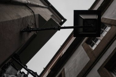 Santiago de Compostela 'nın dar bir sokağındaki eski bir sokak lambasının altında. Arka planda sokak işareti & penceresi ile.