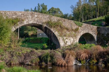 Camino de Santiago 'daki taş Roma köprüsü. Melide, Galiçya yakınlarındaki. Eski taştan nehir suyu gezintisi.