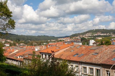 Santiago de Compostela, Galiçya, İspanya - 09 / 22 / 2020: Güneşli bir günde Santiago de Compostela arka planında İspanyol evleri ve tepelerinin manzarası. Evler keşfe çıkar.