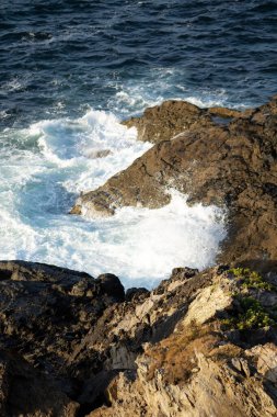 Gün batımında dalgalarla, kayalarla ve rüzgarla